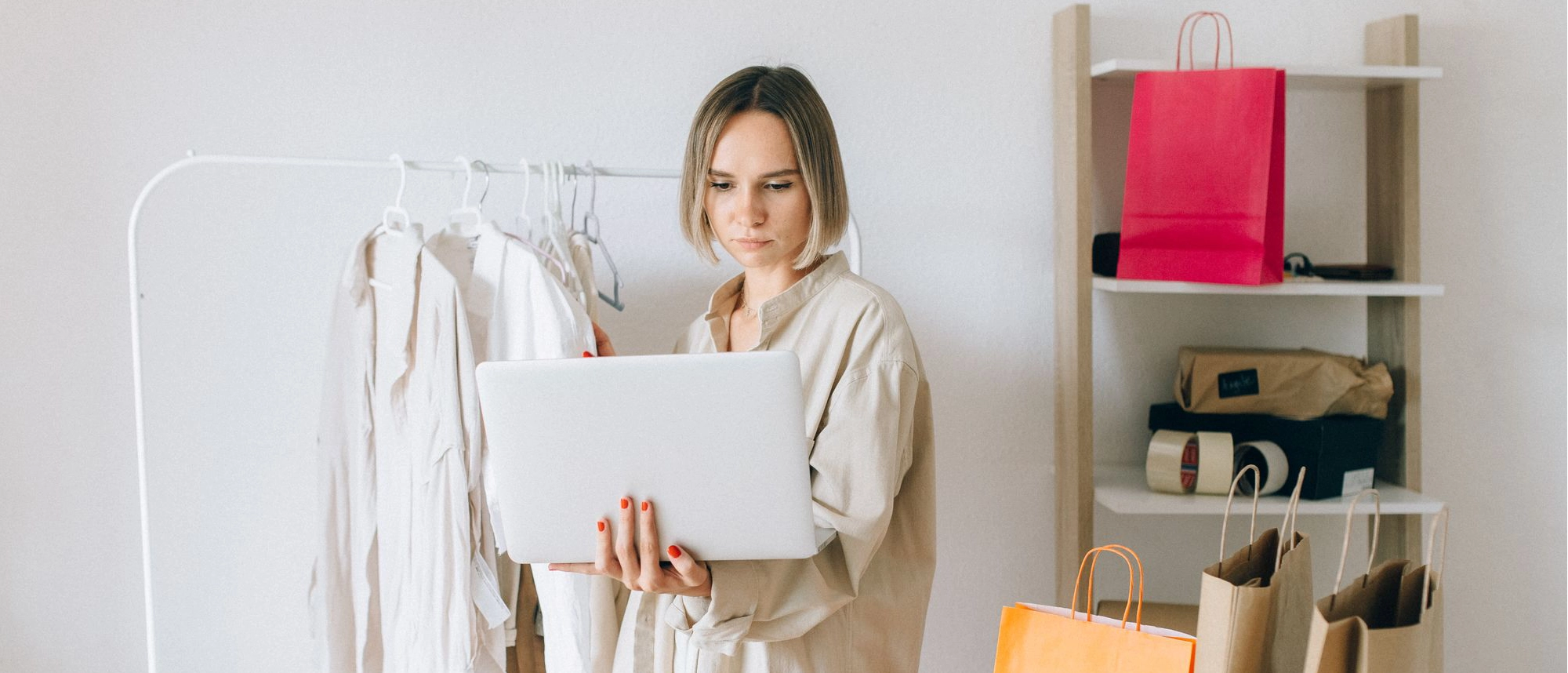 Woman sitting on a bed, reading a Kindle, and decluttering.